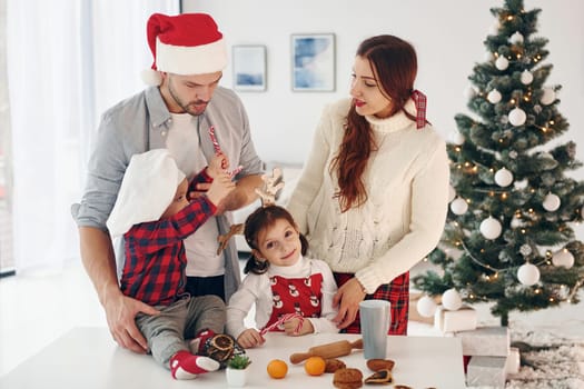 Sister and brother have fun. Beautiful family celebrates New year and christmas indoors at home.