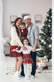 Standing together. Beautiful family celebrates New year and christmas indoors at home.