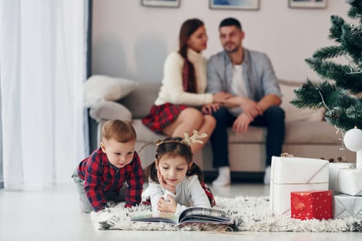 Sister and brother have fun. Beautiful family celebrates New year and christmas indoors at home.