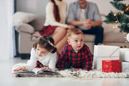 Sister and brother have fun. Beautiful family celebrates New year and christmas indoors at home.
