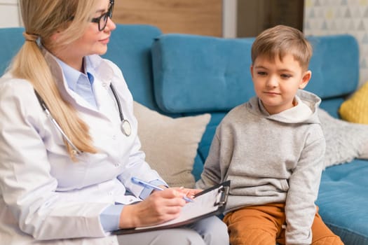 A family doctor examines a little boy at home. Pediatrician girl treats a child.