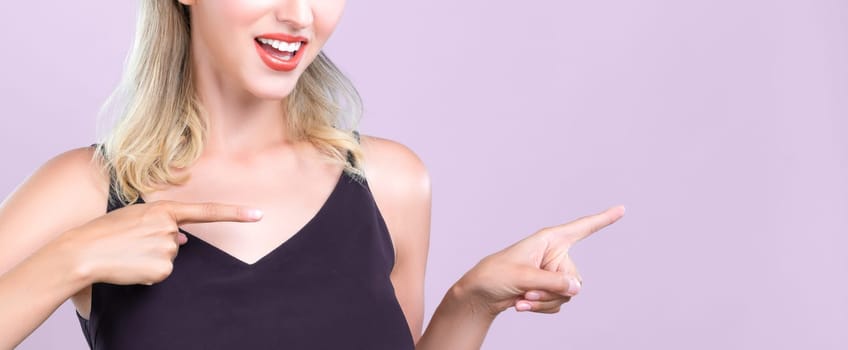 Closeup Alluring beautiful perfect makeup clean skin woman portrait pointing finger side way in copyspace isolated background. Promotion indicated by hand gesture concept for skincare advertisement.