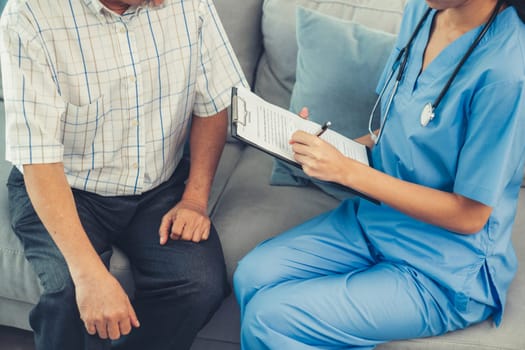 A young female doctor inquires about personal information of a contented senior at home. Medical care for the elderly, elderly illness, and nursing homes, home care.