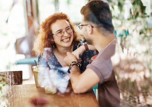 Happy young couple smiling and talking in a coffee shop cafe