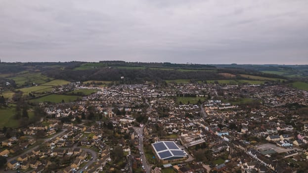 Aerial view of neighborhood surrounded by green landscape. High quality photo