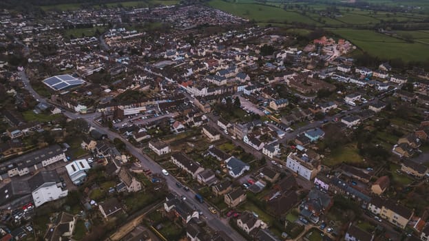 Aerial view of neighborhood surrounded by green landscape. High quality photo