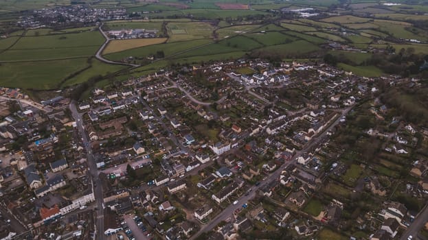 Aerial view of neighborhood surrounded by green landscape. High quality photo