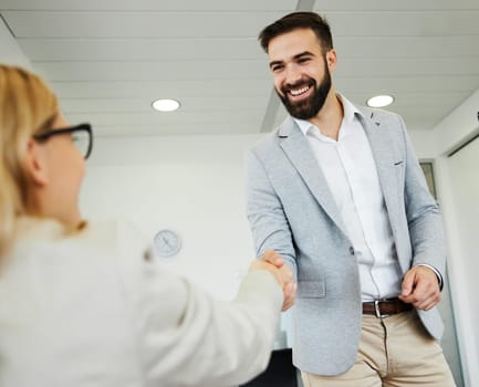 portrait of a young business man offering hand shaking hands introducing in the office