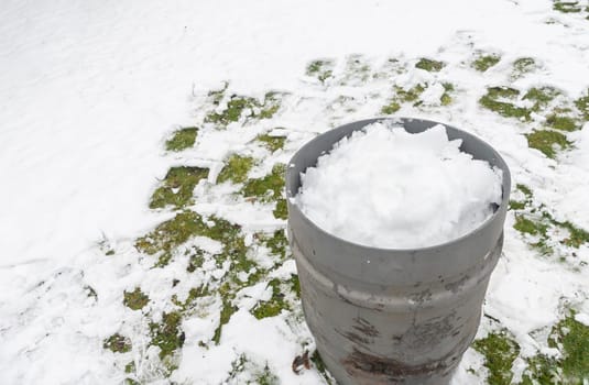 collection of snow in a tank to obtain melted water environmental issues protection day, earth saving natural resources, ecological footprint reduction, High quality photo