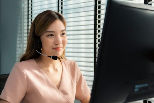 Competent female operator working on computer and while talking with clients. Concept relevant to both call centers and customer service offices.