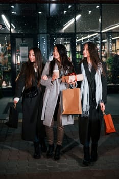 After shopping. Three cheerful women spends Christmas holidays together outdoors. Conception of new year.