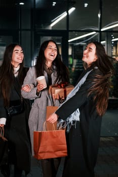 After shopping. Three cheerful women spends Christmas holidays together outdoors. Conception of new year.