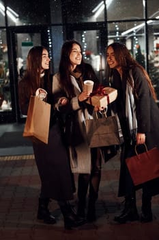 After shopping. Three cheerful women spends Christmas holidays together outdoors. Conception of new year.