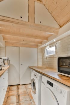 the inside of a house with wood ceiling and white washer, dryer and dishwasher in it