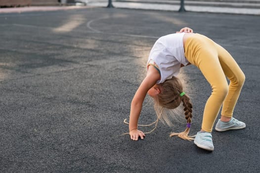 Caucasian girl doing bridge exercise on sports ground outdoors