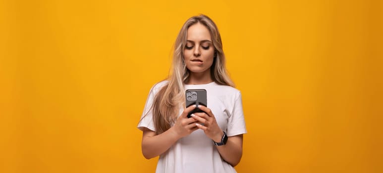 girl with a gadget sits on the Internet on an orange background.