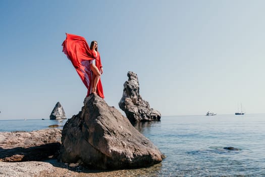 Woman travel sea. Happy tourist taking picture outdoors for memories. Woman traveler looks at the edge of the cliff on the sea bay of mountains, sharing travel adventure journey.