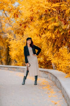 A woman walks outdoors in autumn, enjoys the autumn weather