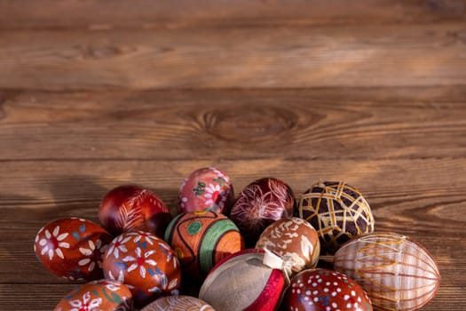 Easter composition of several Easter eggs with brown tones arranged on old brown boards. Blank bowl for adding inscriptions.