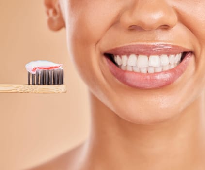 Toothpaste, bamboo toothbrush and smile of woman in studio isolated on a brown background. Sustainable, eco friendly and face of happy female with wood brush for brushing teeth and dental health