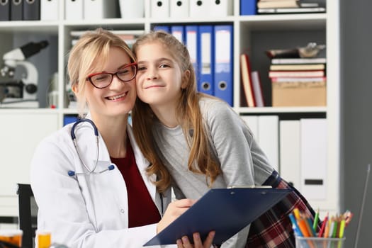 Smiling doctor and baby girl together in clinic. Medical insurance for children and medical friendly contact with children