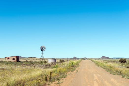 An abandoned farm worker house, windmill and dam next to road S129 between Luckhoff and Fauresmith in the Freestate Province