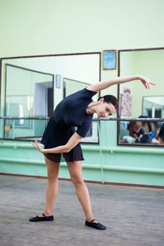 Beautiful student dancer warming up before lesson of choreography