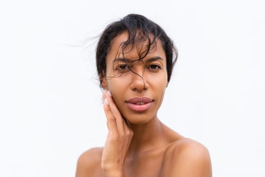 Beauty portrait of young topless african american woman with bare shoulders on white background with perfect skin and natural makeup positive