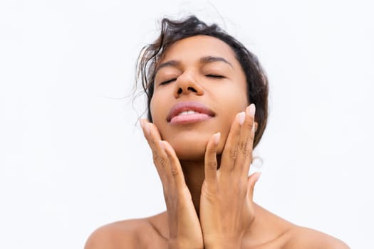 Beauty portrait of young topless african american woman with bare shoulders on white background with perfect skin and natural makeup positive