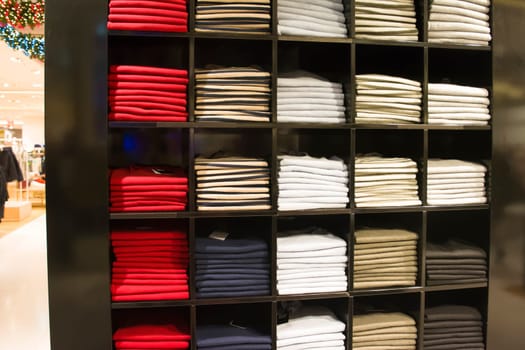 A row of folded jackets on a shelf in the store