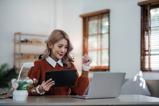 Young asian woman using tablet with smiling face, positive emotion, at home, casual home life concept..