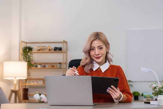 Young asian woman using tablet with smiling face, positive emotion, at home, casual home life concept..