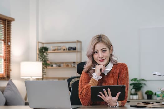 Young asian woman using tablet with smiling face, positive emotion, at home, casual home life concept..