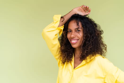 Beautiful african american woman in casual shirt on green background positive smiling laughing enjoying execited