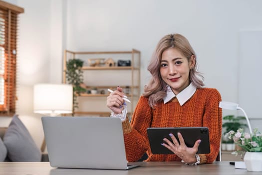 Young asian woman using tablet with smiling face, positive emotion, at home, casual home life concept..