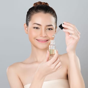 Glamorous portrait of beautiful woman applying extracted cannabis oil bottle for skincare product. CBD oil dropper pipette for cosmetology treatment and cannabinoids concept in isolated background.