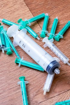 Syringes scattered on the wooden floor close up