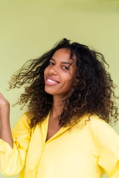 Beautiful african american woman in casual shirt on green background positive smiling laughing enjoying execited