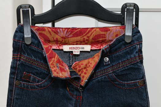 PARIS - FRANCE - 05 March 2023 - Kenzo label on a jeans for kids. A luxury fashion brand