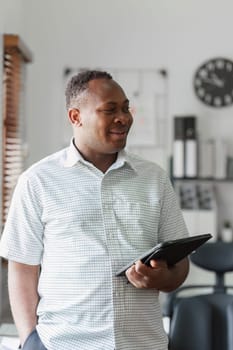 Smiling confident African American businessman at office. Strategy, chart, finance report concept.