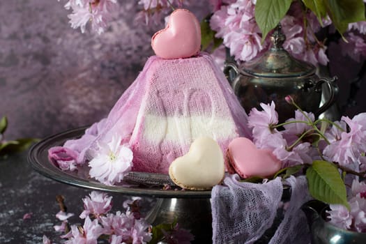 sweet curd orthodox easter on a background of purple sakura and heart-shaped macaroons, traditional food, High quality photo