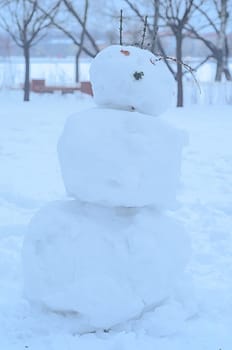 Winter snowman in the park.Vertical photo.