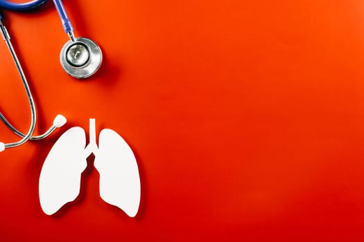 World Tuberculosis Day. Overhead lungs paper symbol and medical stethoscope on red background, lung cancer awareness, copy space concept of world TB day, banner background, pneumonia awareness