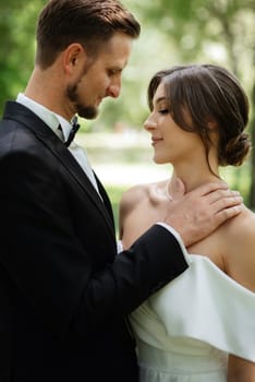 the first meeting of the bride and groom in wedding outfits in the park