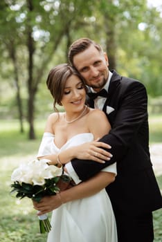 the first meeting of the bride and groom in wedding outfits in the park