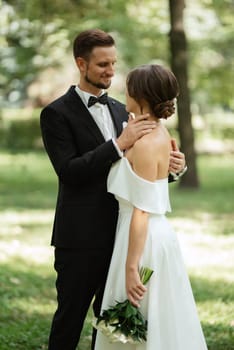 the first meeting of the bride and groom in wedding outfits in the park