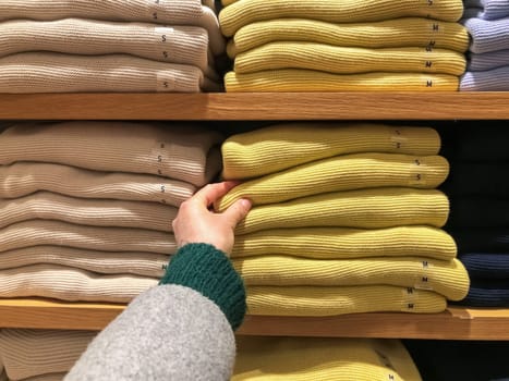 Woman's hand chooses a sweater