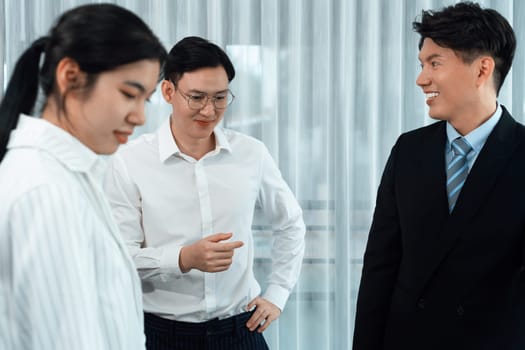 Mentor, manager advice younger colleagues in workplace. Businesspeople discussing or planning financial project strategy, talking together for harmony and strong teamwork in office concept.