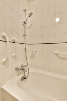 a bathroom with white tiles and black lines on the wall, as seen from the corner of the bathtub
