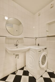 a bathroom with black and white checkered tiles on the floor, along with a washer and dryer